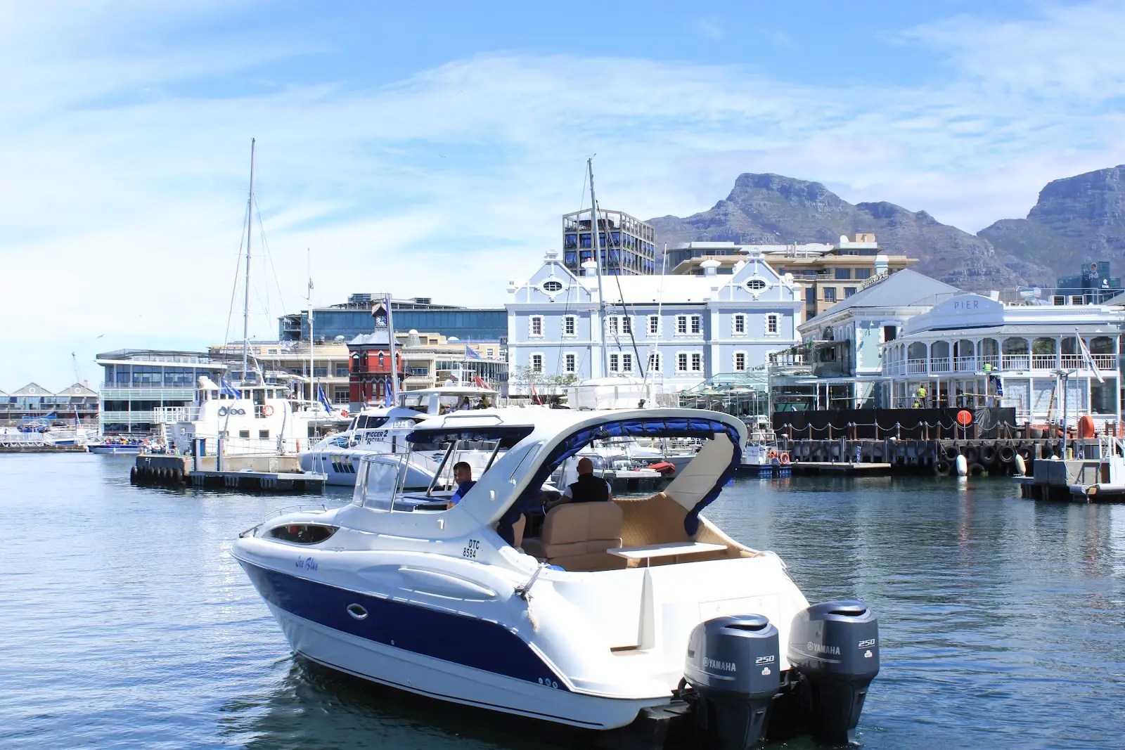 Ice Blue motor yacht at the V&A Waterfront with Table Mountain in the background.