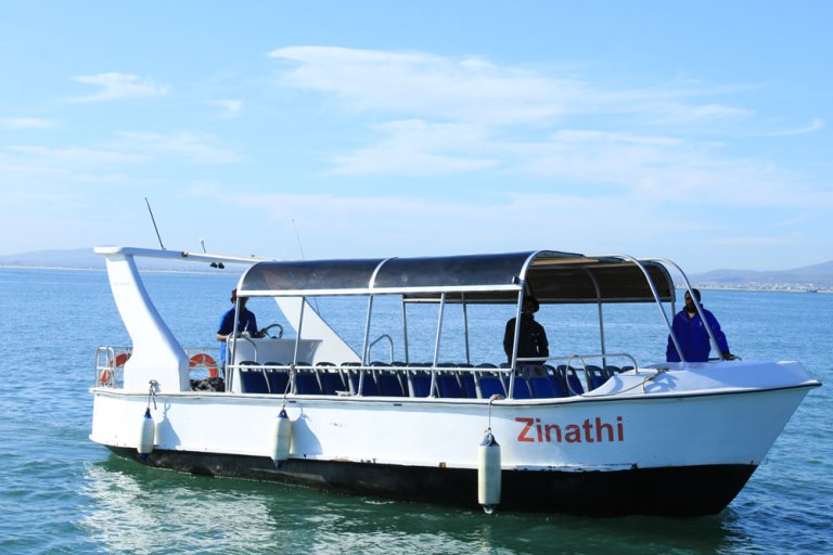 White boat named Zinathi on water with two people aboard.